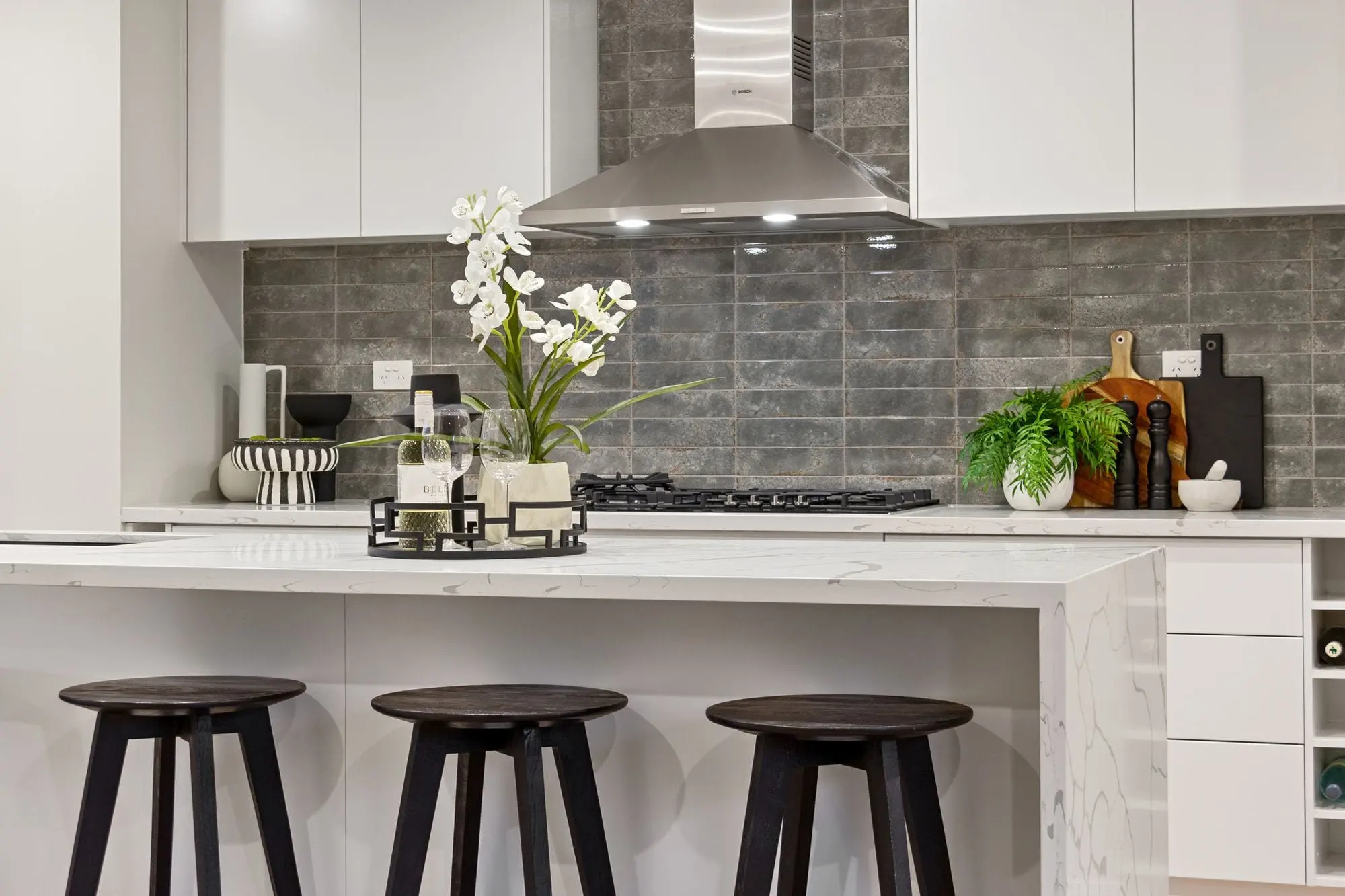 A bright, freshly cleaned residential kitchen with a clear island bench and natural light.