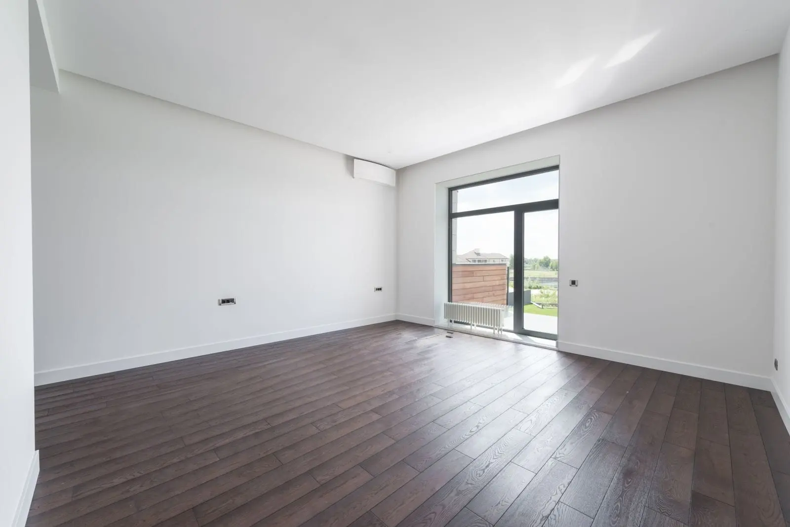 An empty residential living room with clean floors and clear walls, ready for a final inspection.